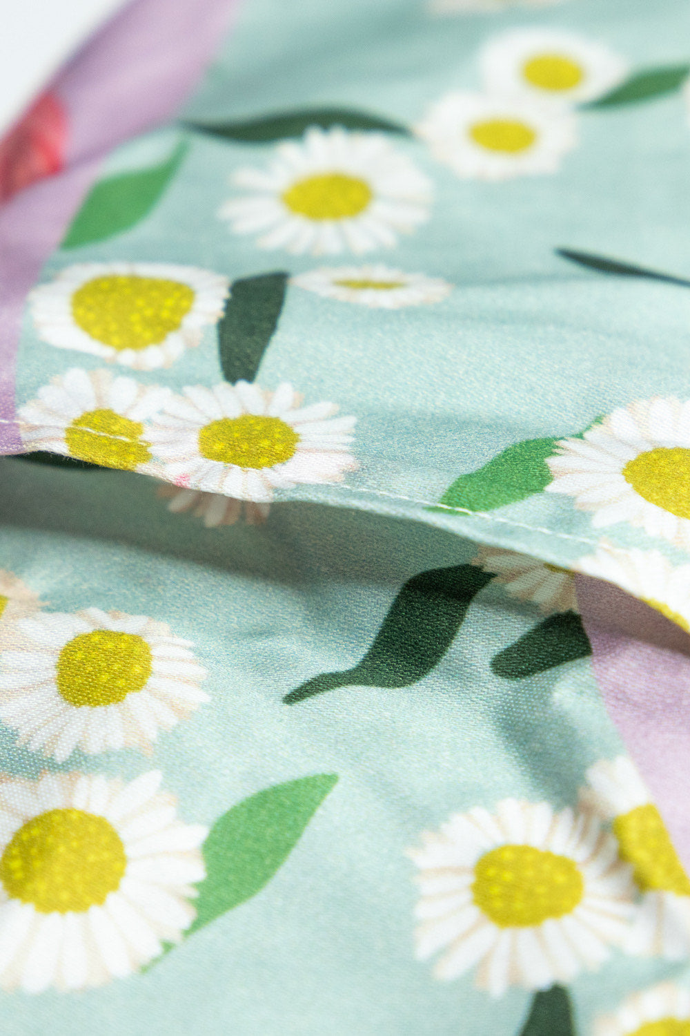 Sherrie Morgan Design relaxing eye pillow with a soft protea and daisy flower print in pink and turquoise, close up picture of removable cover opening.