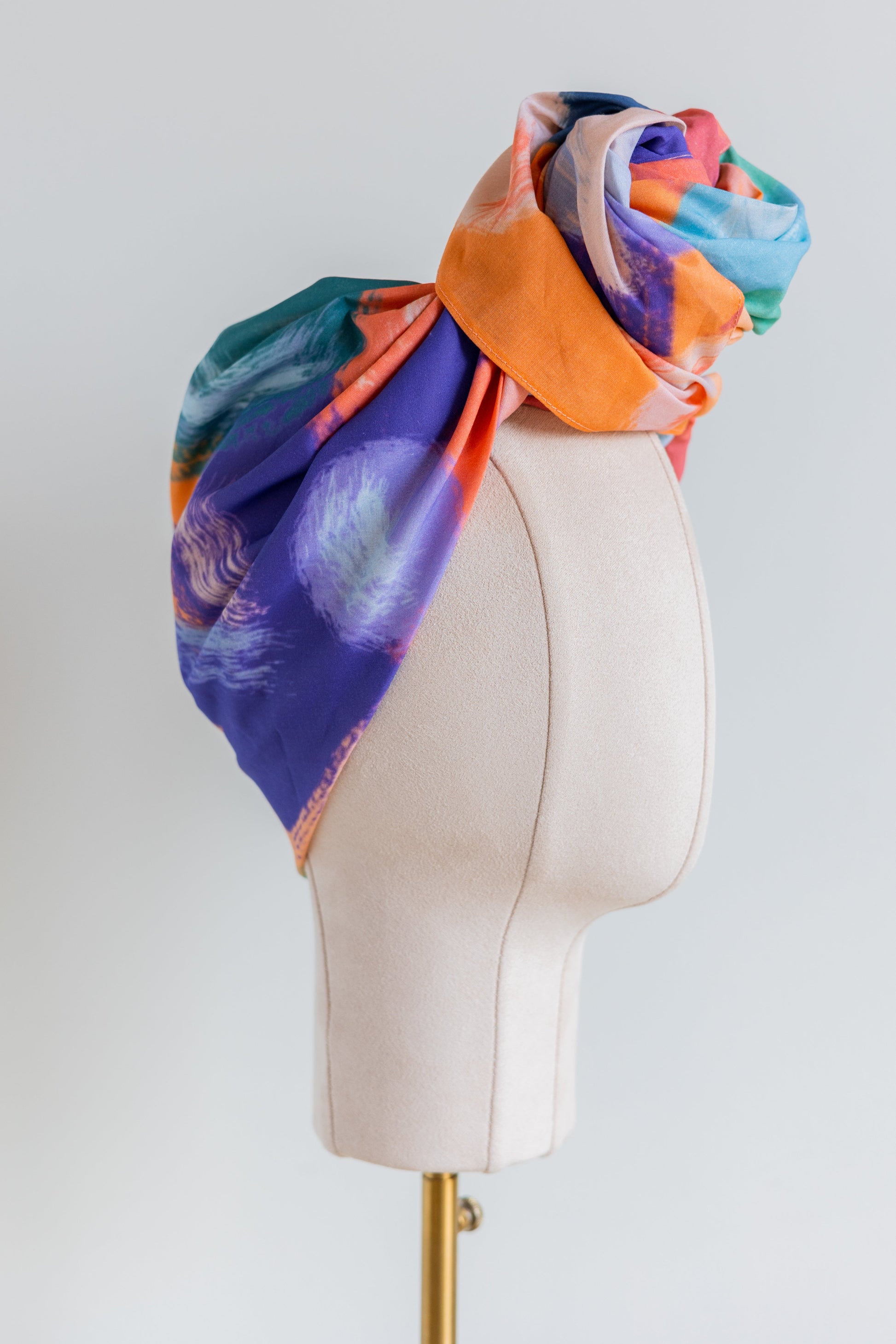 SMD original art 'Party time', vivid orange, blue and green shapes resemble party confetti, displayed as a turban with a large top knot, side view