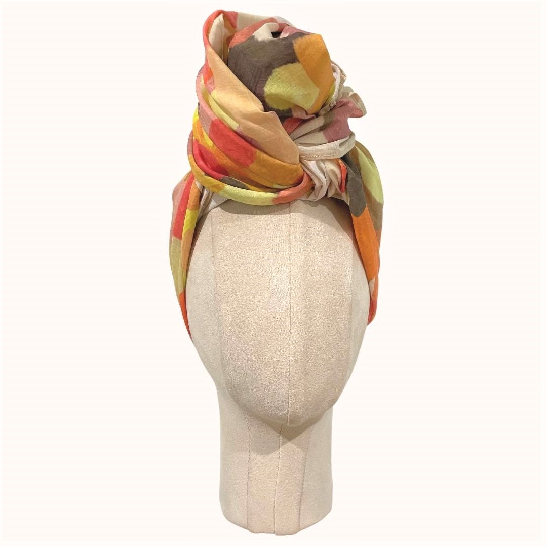 SMD original art scarf, yellow, orange, red shapes resembling the outback sunsets, displayed as a headwrap, front view