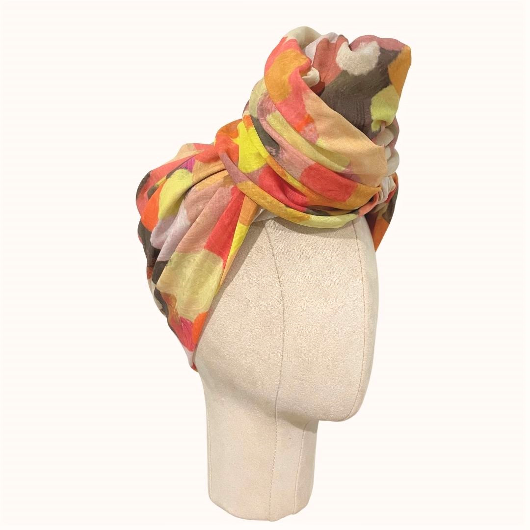 SMD original art scarf, yellow, orange, red shapes resembling the outback sunsets, displayed as a headwrap, side view