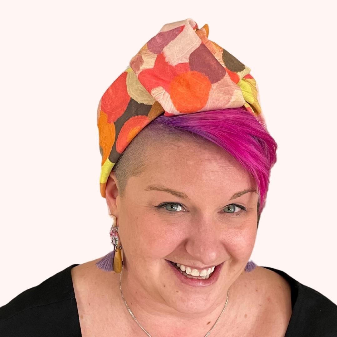 SMD original art scarf, yellow, orange, red shapes resembling the outback sunsets, displayed as a headwrap, side view on model