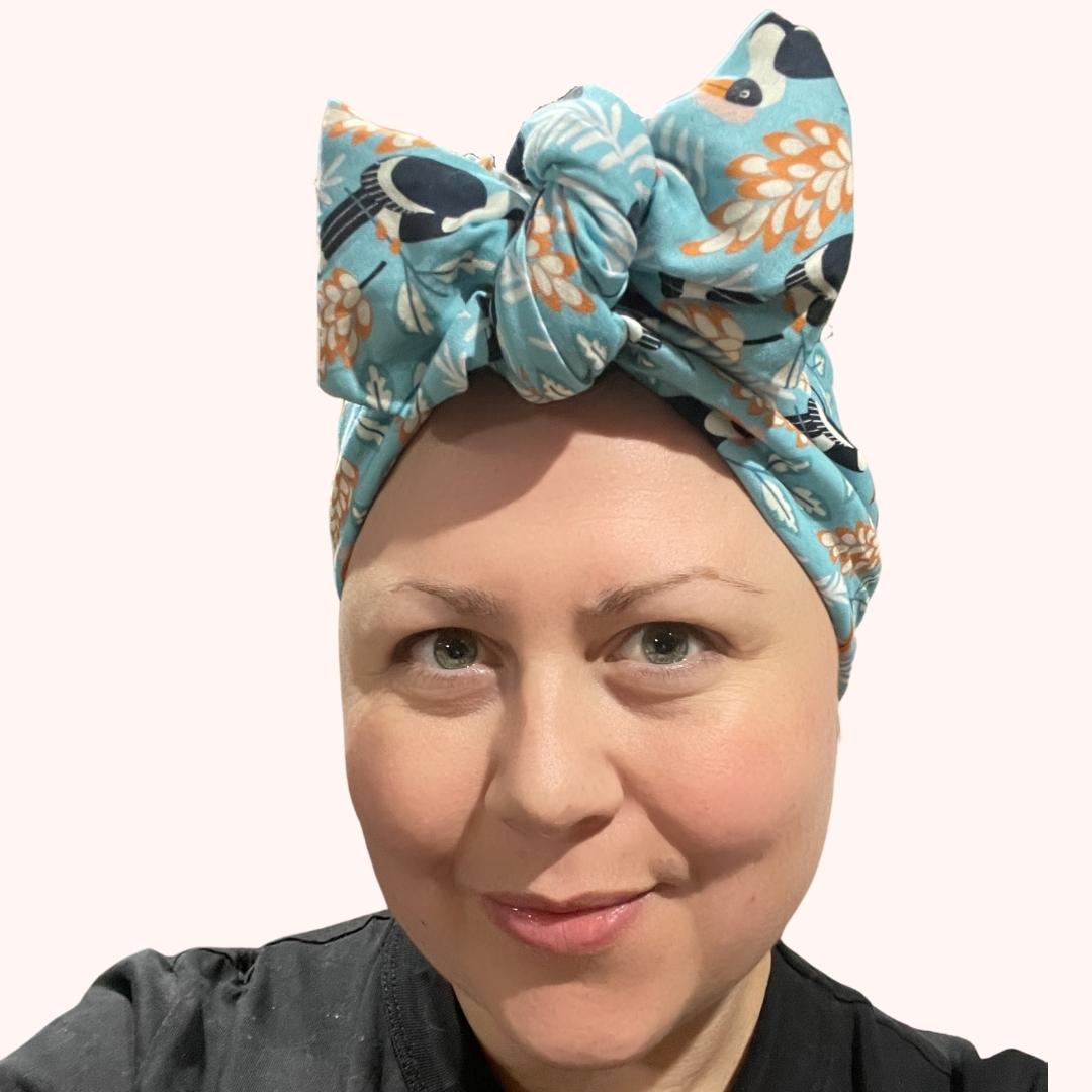 SMD scarf, toucan birds on a birght blue base, headscarf shown in a large bow, front view