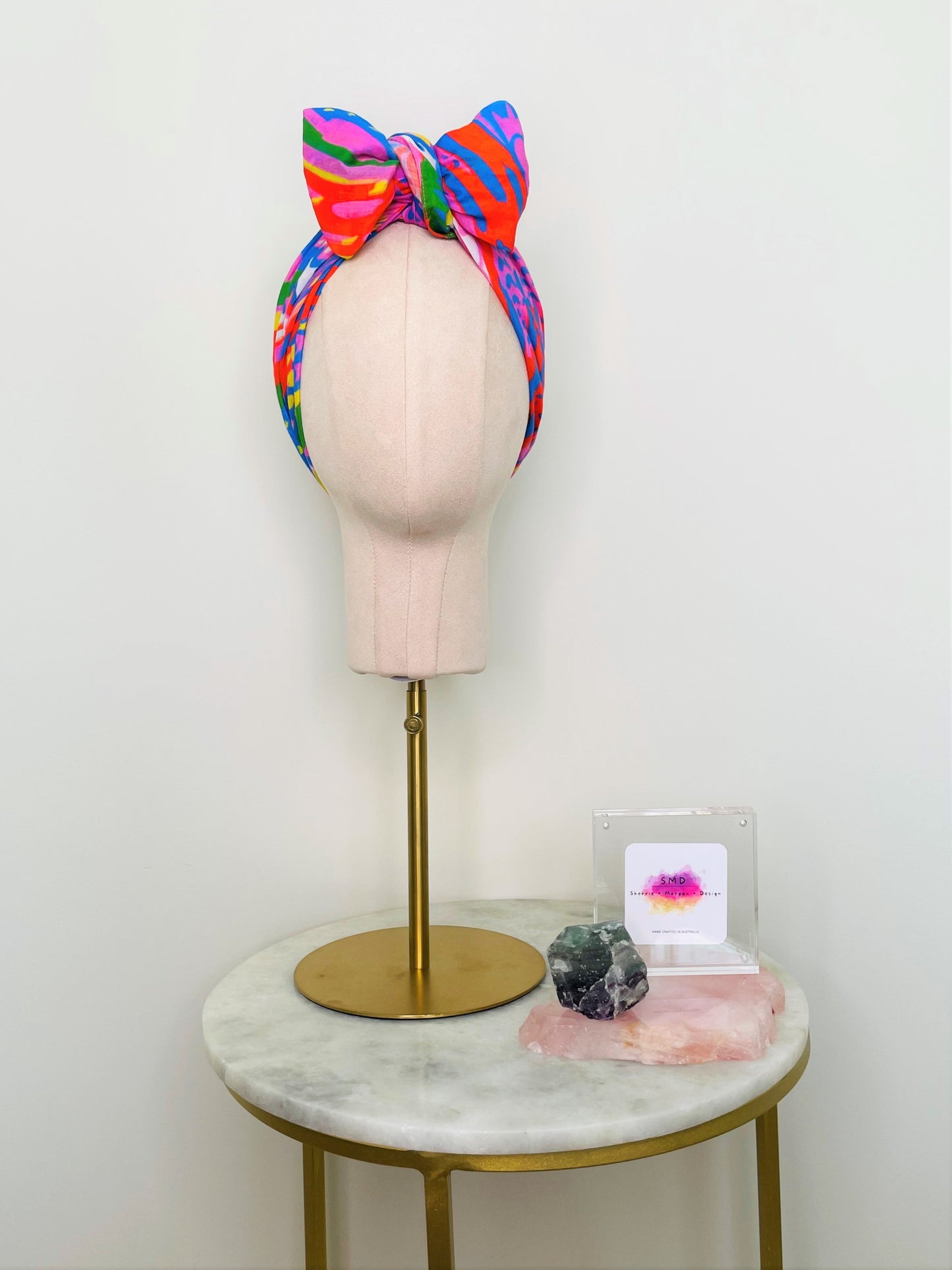 SMD scarf, bright colourful abstract lines pattern, red, yellow, blue, green, pink, shown as headwrap with large bow, design Katie Kortman, front view