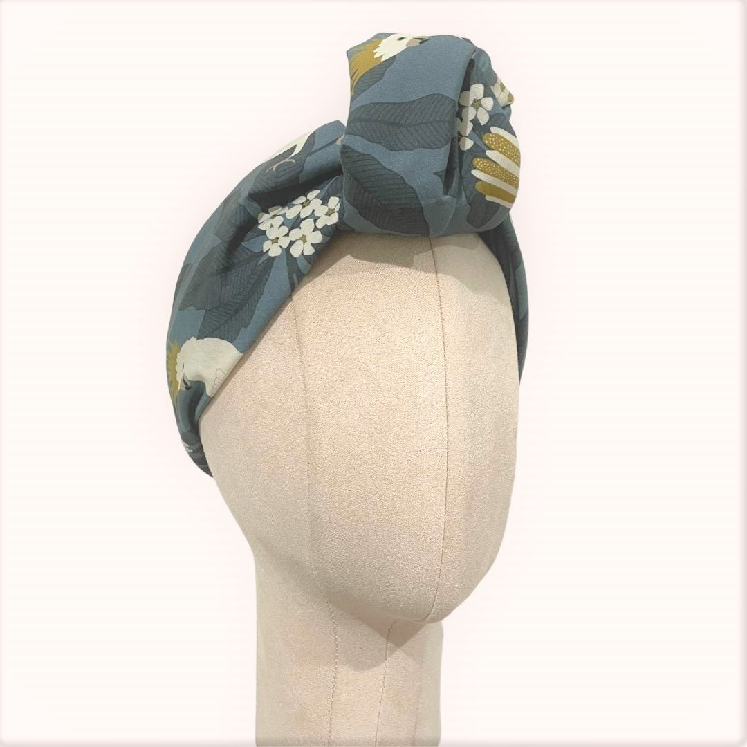 SMD scarf, Jocelyn Proust design, white galahs on a grey base, displayed as a headscarf with large knot, side view