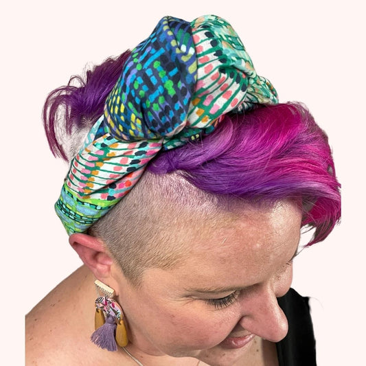 SMD scarf, Miss Moresby green lines design, displayed as a headband with side knot, top view