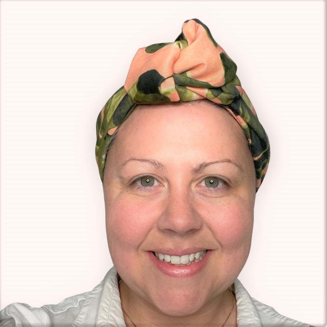 SMD scarf, large monstera leaves design by Australian designer Nerida Hansen on apricot base, shown as headwrap with large knot, front view