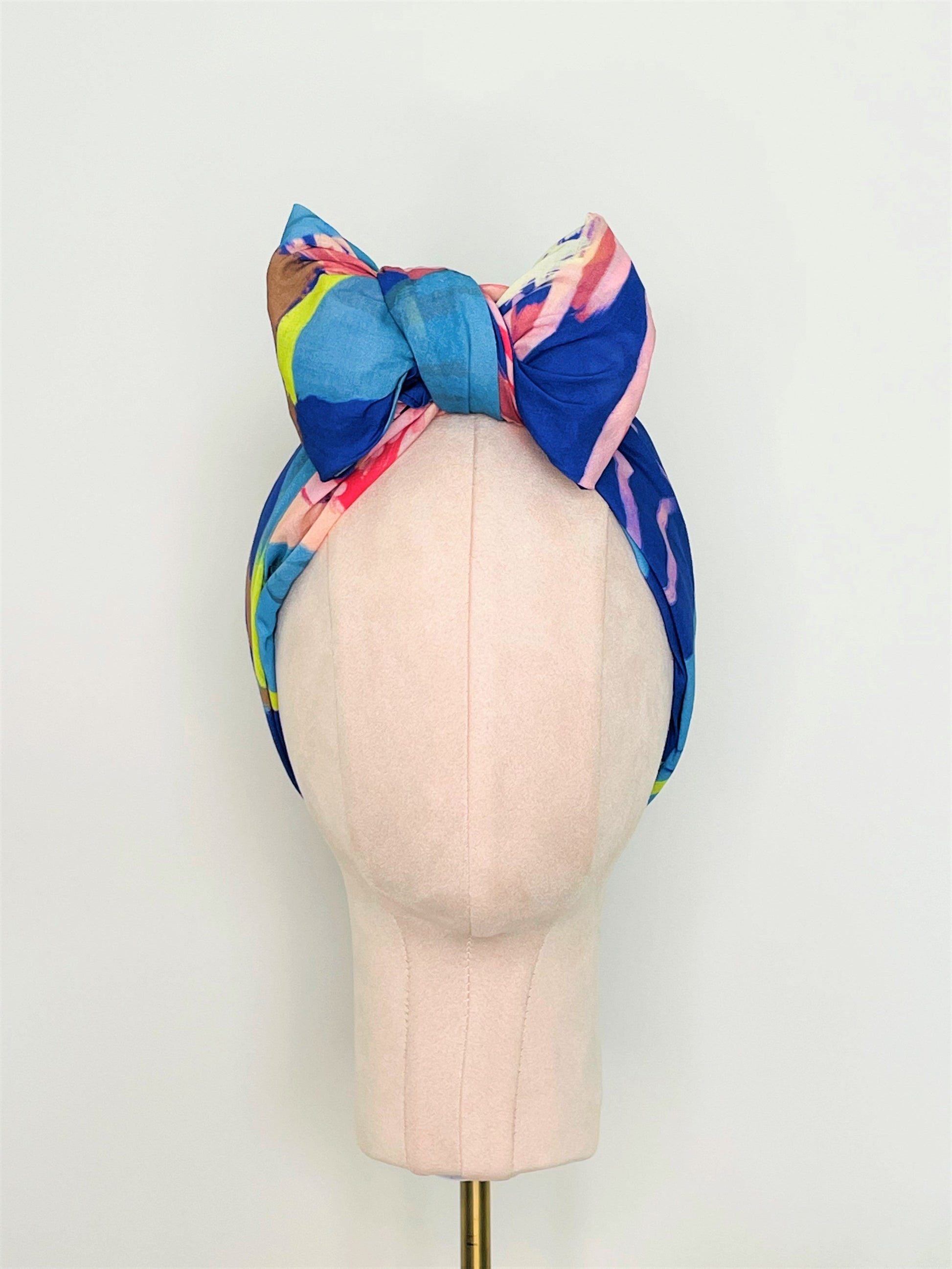 SMD original art 'Protea Multiplied', large pink king protea on a marine blue base, displayed as headscarf with a front bow, front view