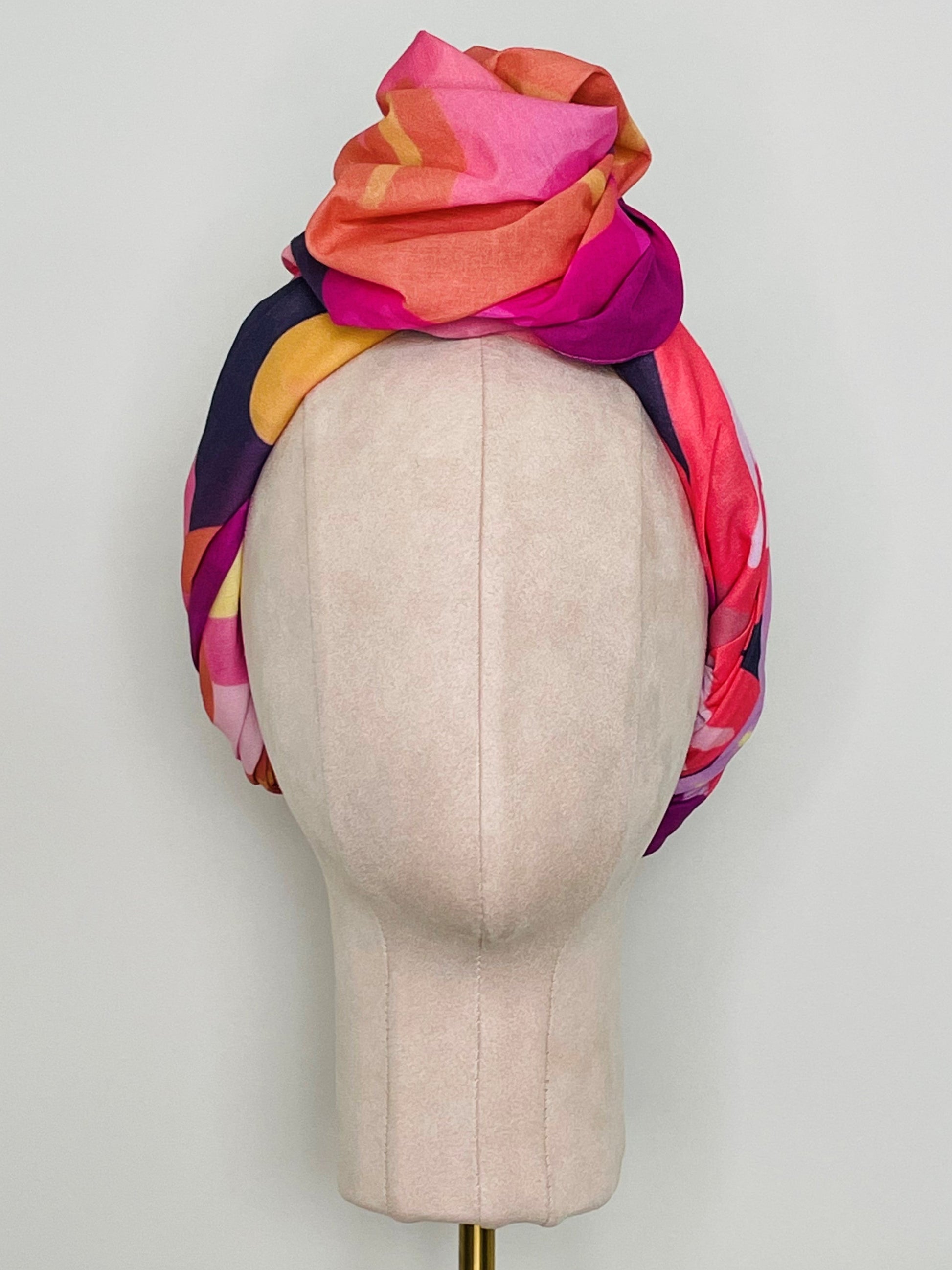 SMD original art 'Retro Floral Pink',  pink, purple and orange floral design, displayed as a head turban with large top knot, front view