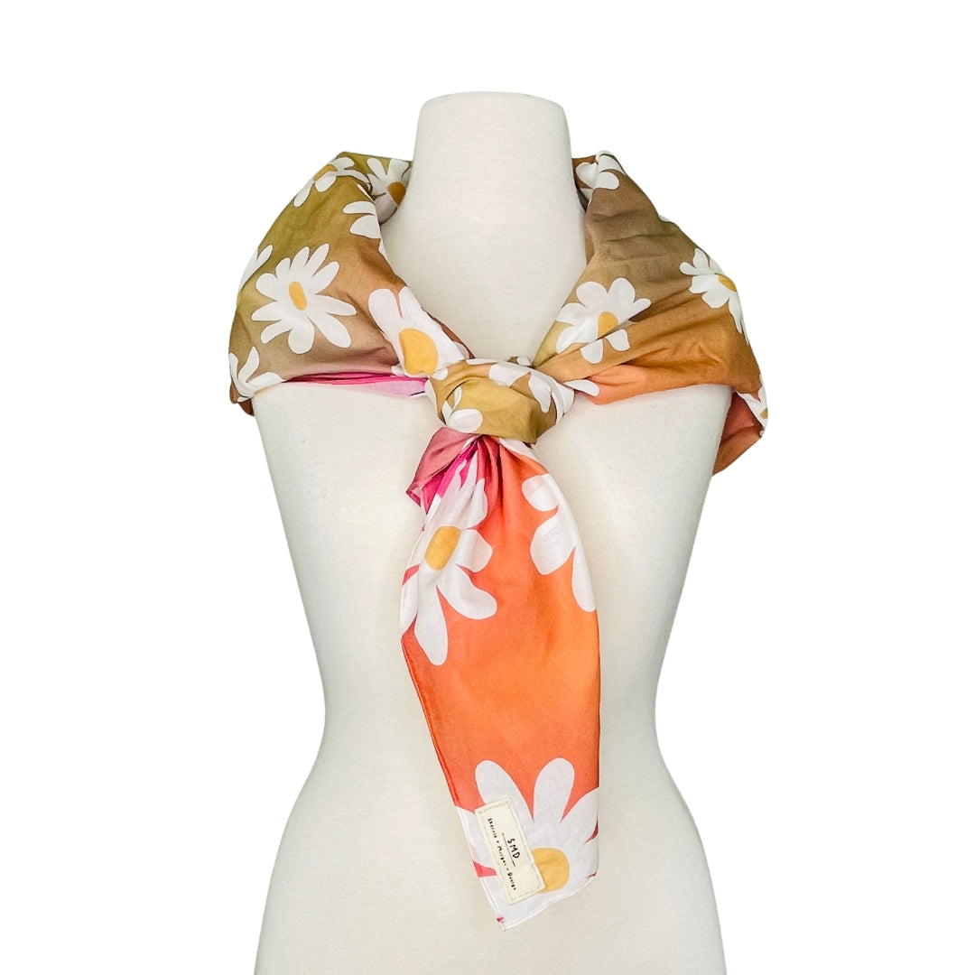 SMD original art 'Oh Daisies sunset', white and yellow daisies on an orange, red and pink background. Displayed as a neck scarf.