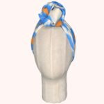 SMD original art All fired Up, blue and orange animal print  shown as a head wrap with a twisted knot, front view.