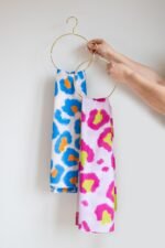 SMD original art All fired Up, blue and orange animal print  hanging on a gold hanger with Wild One - another SMD original.