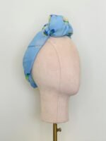 SMD scarf, design by Margaret Jeane,  pears on blue base, scarf displayed as headwrap with top knot, side view