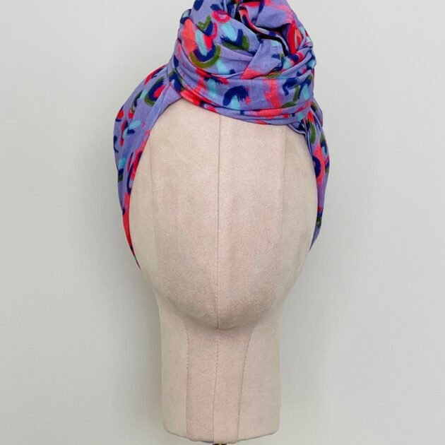 SMD scarf, coral and lilac abstract rain print, by Katie Kortman, displayed as twisted headwrap, front view