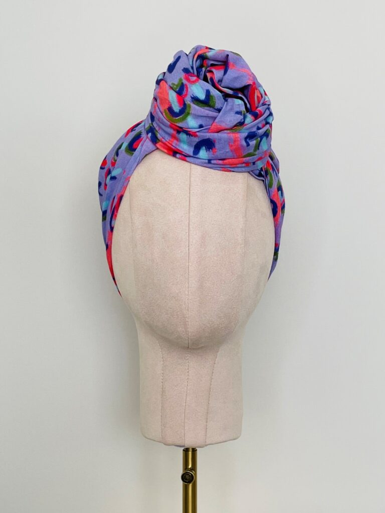 SMD scarf, coral and lilac abstract rain print, by Katie Kortman, displayed as twisted headwrap, front view