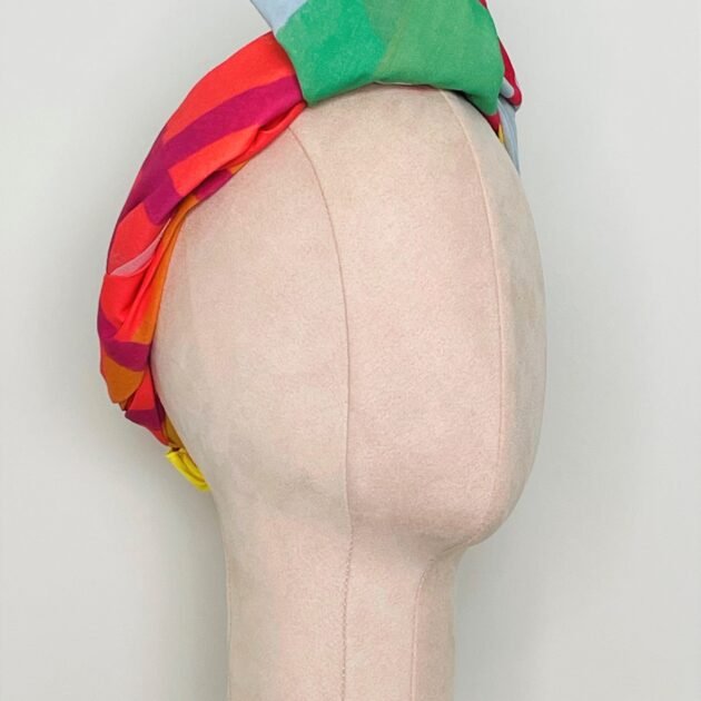 Sherrie Morgan Design original art, colourful large fruit design, yellow, orange, green, blue, red. Shown here as a knotted headscarf, Side view.