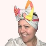 Sherrie Morgan Design original art, colourful large fruit design, yellow, orange, green, blue, red. Shown here as a large bow headscarf, Side view.