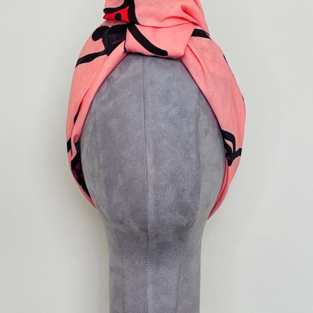 SMD original art 'Hey There', featuring a winking face with red lips on a pink base, displayed as head turban, front view