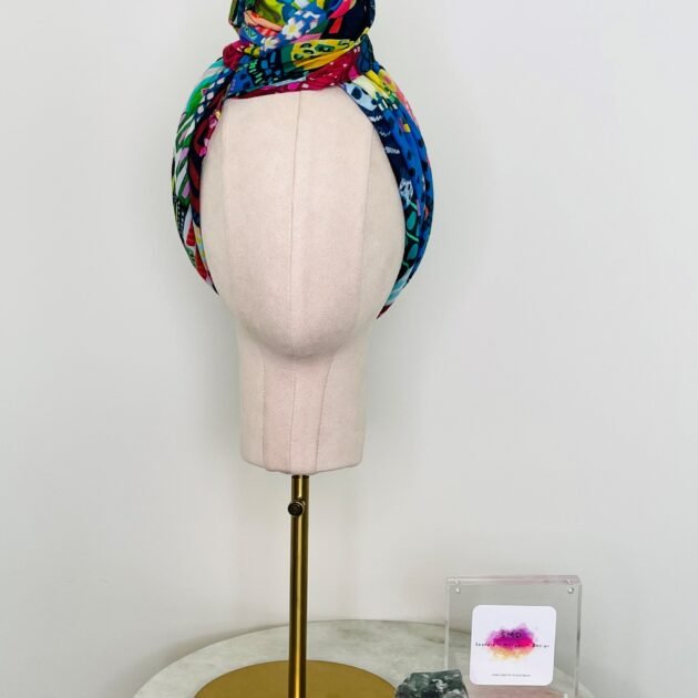 SMD scarf, Miss Moresby multicoloured design, displayed as a headscarf, front view