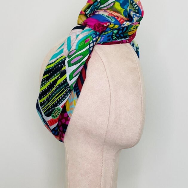 SMD scarf, Miss Moresby multicoloured design, displayed as a headscarf, side view