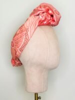 SMD scarf, Emma Stenhouse design in orange, displayed as a headwrap with a top knot, side view