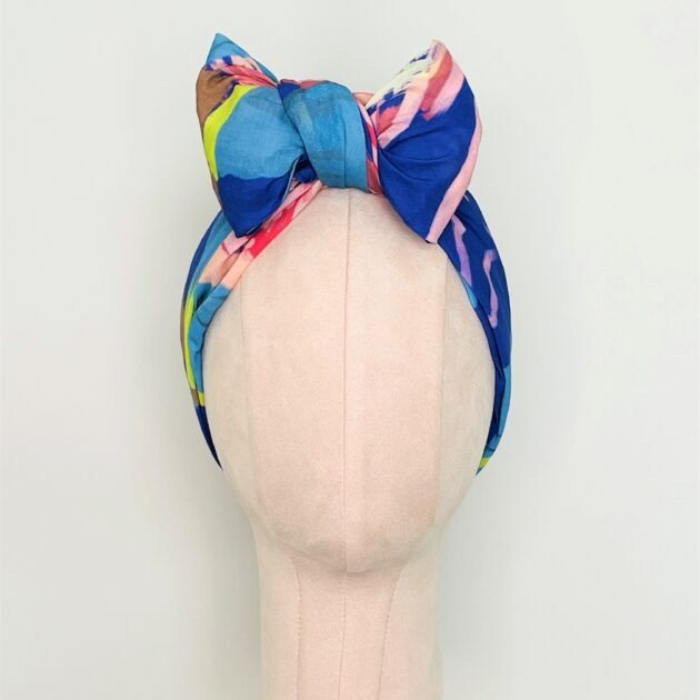 SMD original art 'Protea Multiplied', large pink king protea on a marine blue base, displayed as headscarf with a front bow, front view