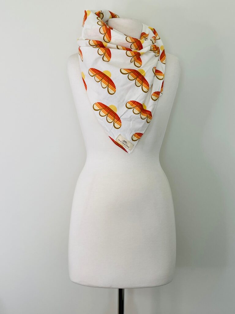 SMD scarf, upcycled fabric featuring a 70's retro floral pattern in yellow and orange, displayed as a neck scarf