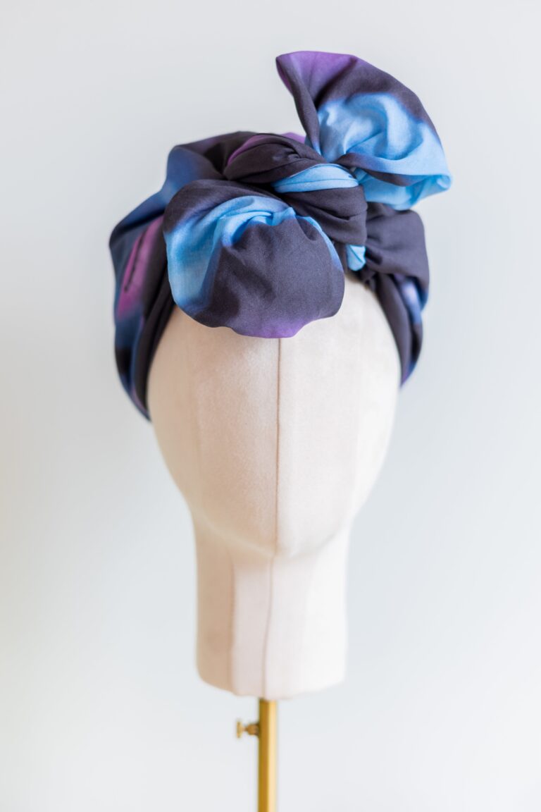 SMD original art 'Spacewalk' dark navy base with chain link, displayed as a head turban with bow, front view.