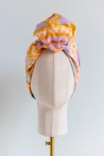 SMD original art 'Under the Sea' colourful peach, purple and green starr seabed, featured as a head wrap with large knot, front view