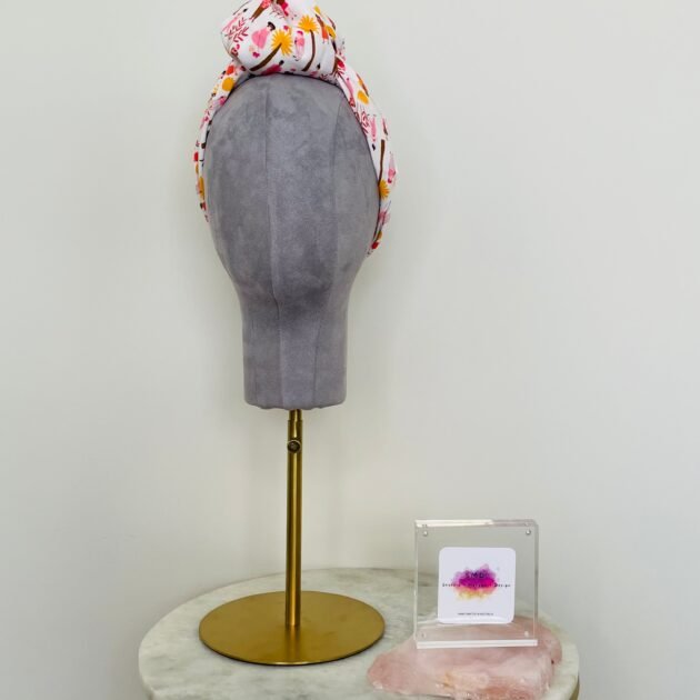 SMD scarf, white base with ladies and dogs walking in pink and yellow, knotted headscarf, front view